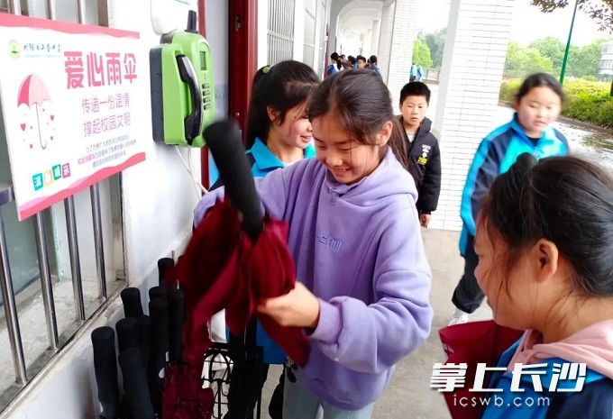 需要用伞的同学在取用“爱心雨伞”。照片由学校提供。