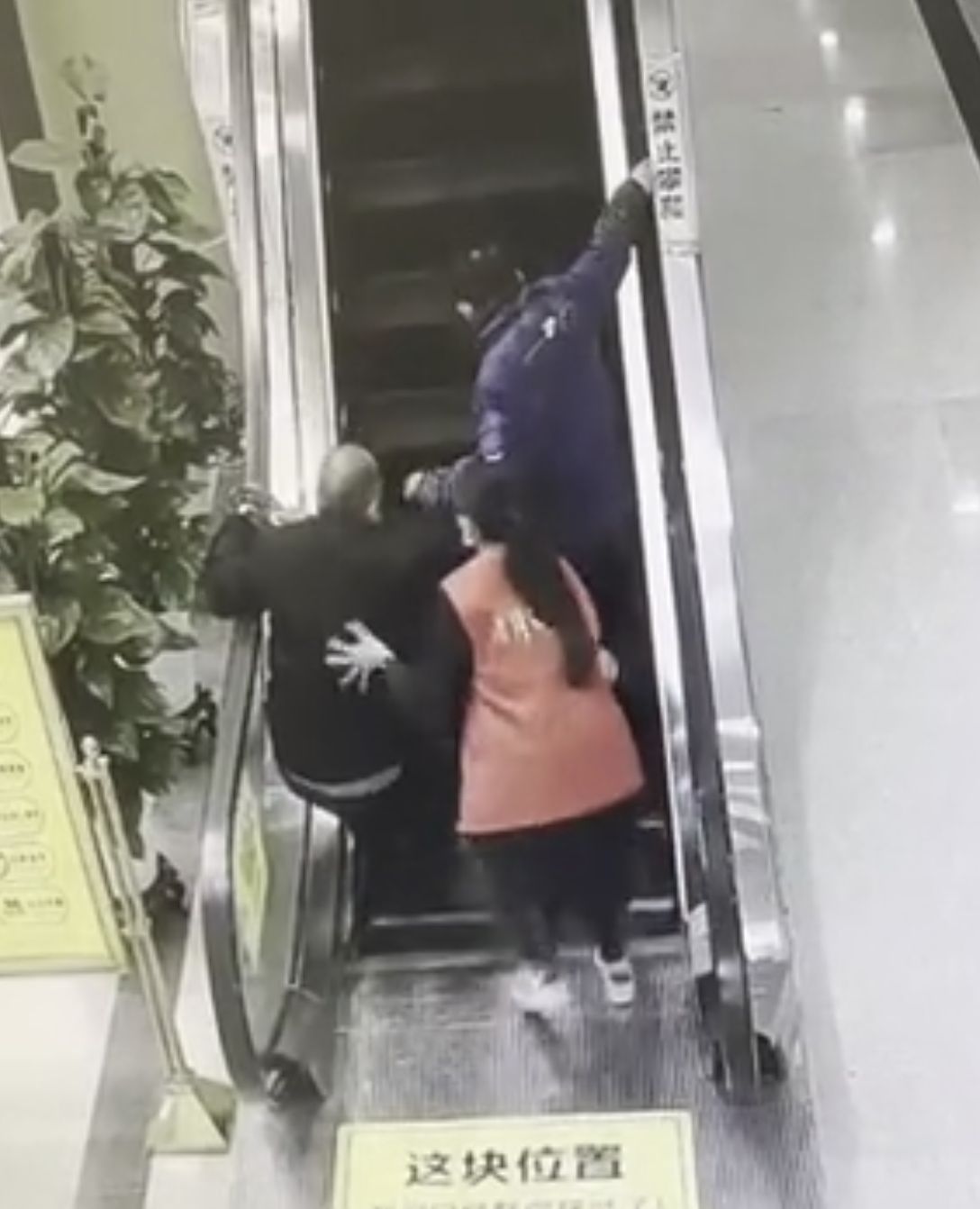 老人向后摔倒之际，守在身后的志愿者丰云一把扶住老人。 视频截图