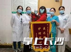 萌萌出院前,妈妈抱着他与医护人员合影留念。医院供图 萌萌出院前,妈妈抱着他与医护人员合影留念。医院供图