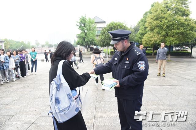 民警发放宣传单页，让普法宣传进校园。