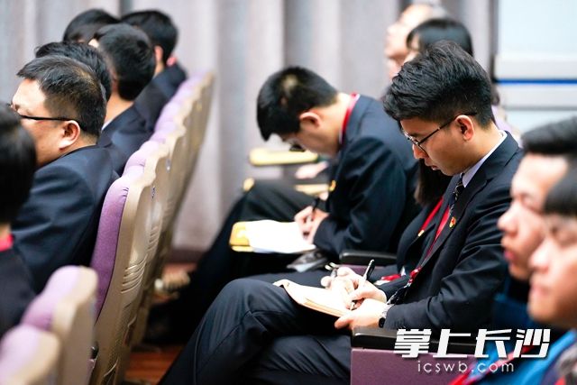 聆听党史报告会，企业员工非常认真地做着笔记。
