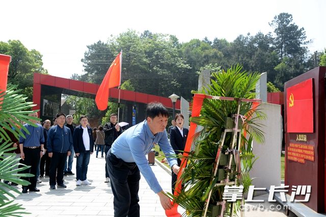 学习团代表上前为花篮整理缎带。 