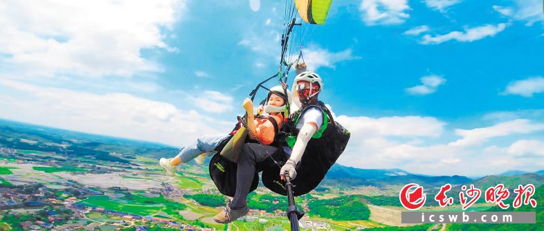 彩色滑翔伞从高山上飘扬而下，欢声笑语洒落黑麋峰山间。景区供图