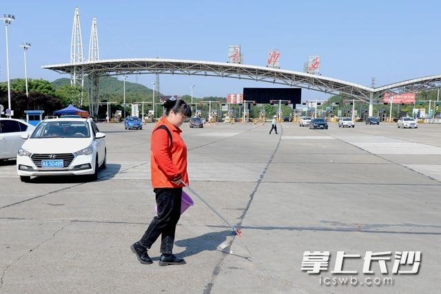 雷锋志愿者对长沙西收费站进行卫生清扫。