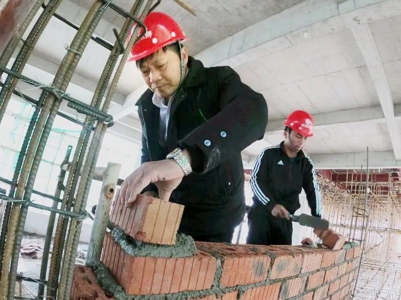 ▲周科明带徒弟“传帮带”示范砌墙。