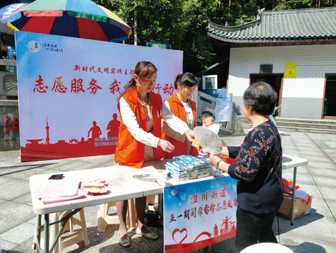 在淮川街道志愿服务点，几名志愿者积极地为游客提供旅游咨询、安全指引、应急药品等便民服务。淮川街道供图