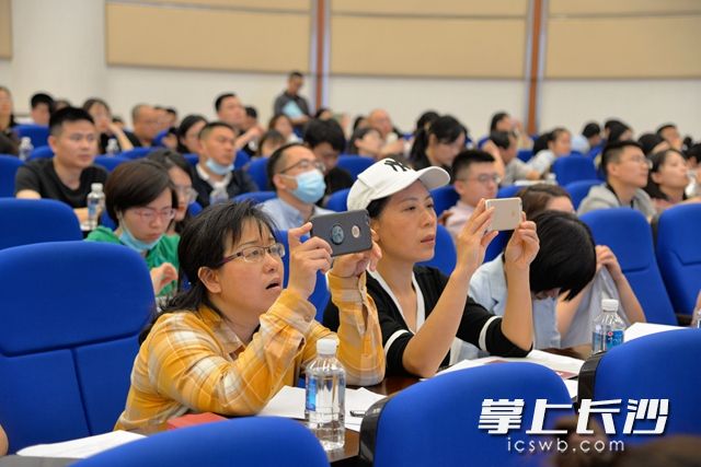 与会人员纷纷拿出手机拍摄培训课重点内容。