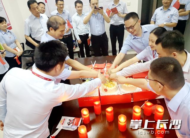  党员们齐动手、共分享，迎接着“生日蛋糕”的到来。