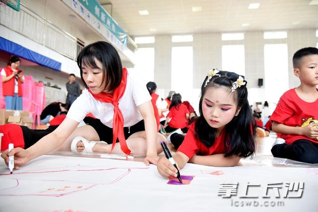 师生在长长的画布上用心绘画着属于自己的中国梦。