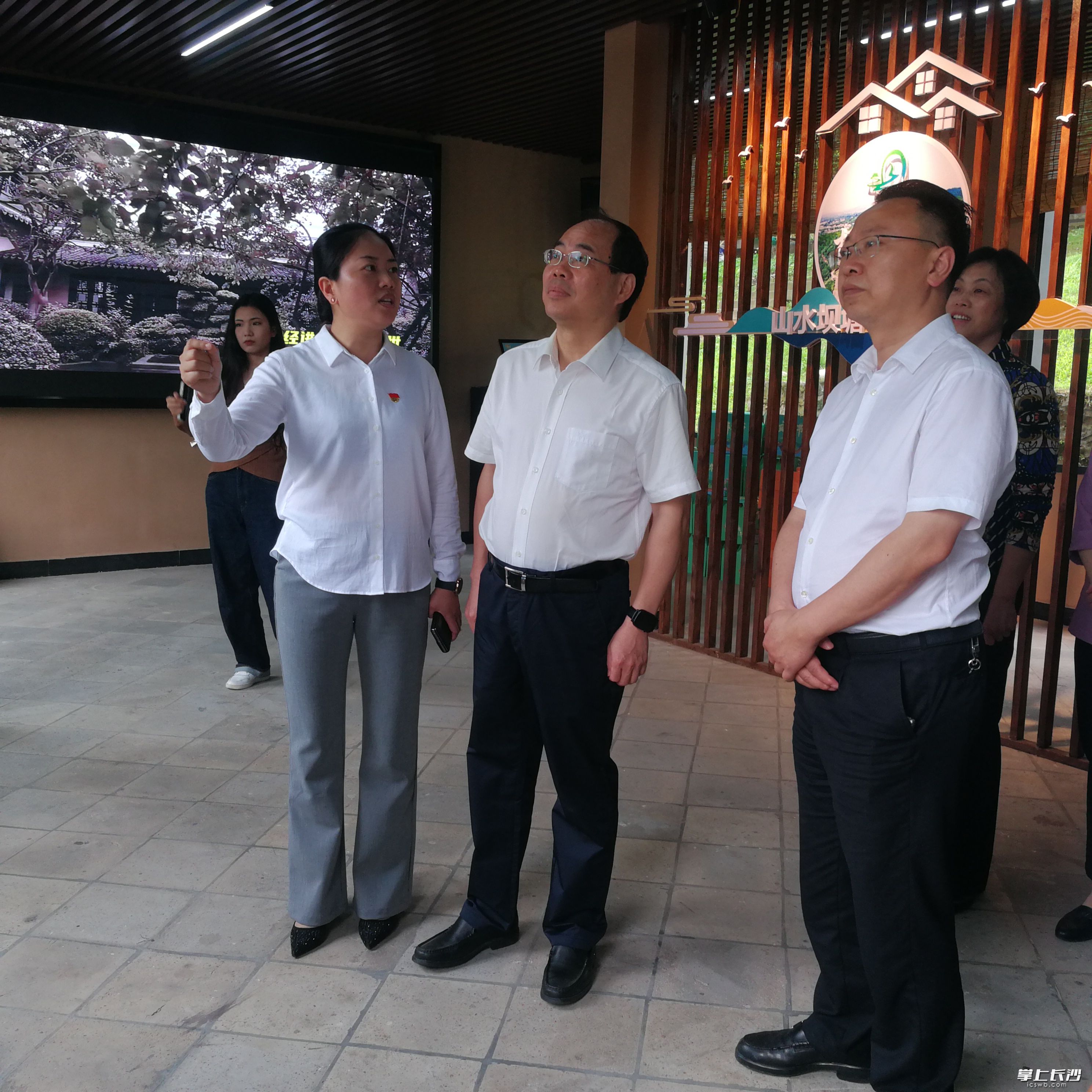 长沙市委常委、市委统战部部长谭小平（中）在听取坝塘镇党委书记田奇晖介绍产业发展情况。 长沙晚报全媒体记者 黎铁桥 摄