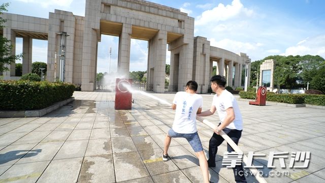 两人齐心协力，利用水压抢，扑灭“大火”。