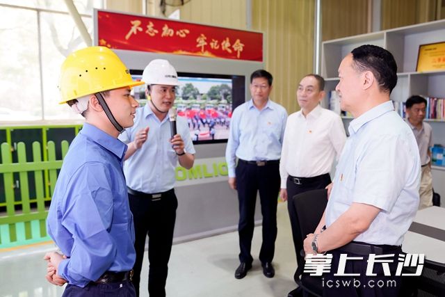 在泵车装配车间，考察团走进车间里的党建阵地，与党员进行深入交流。
