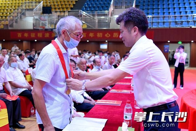 区党工委委员、人大政协联络办主任江从平（右）出席活动并为“光荣在党50年”老党员颁发纪念奖章。