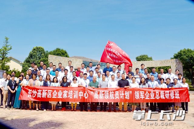 与会人员高举班旗，相约合影留念，记录这段难忘的学习经历。