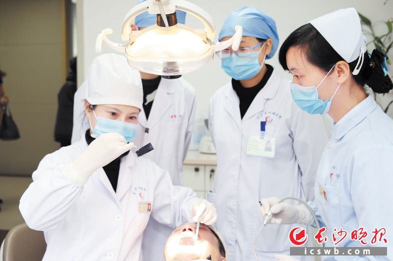 长沙市口腔医院的专家正在为患者进行口腔疾病治疗。医院供图