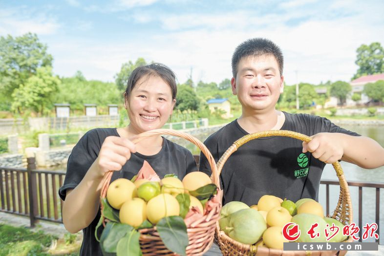 舒岳礼和妻子高小岚满身是汗，笑着展示劳动成果。长沙晚报全媒体记者 朱华 摄