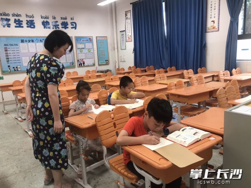 岳麓区麓山国际实验小学自习室里，老师正在辅导暑假来校参加自习的学生。   长沙晚报全媒体记者 岳霞 摄