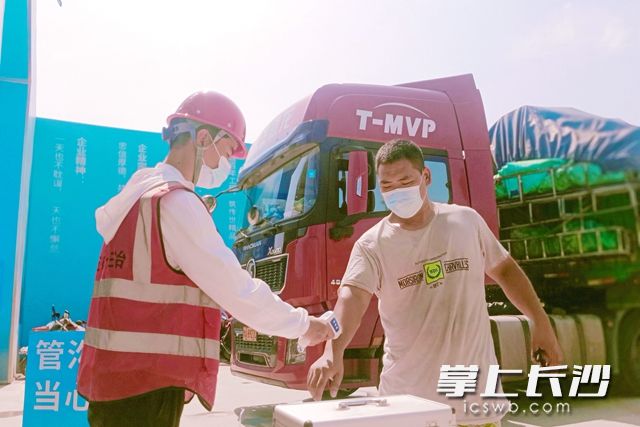 8月1日，五矿二十三冶车用锂电池扩产项目现场，工作人员正在对工人进行体温测量。