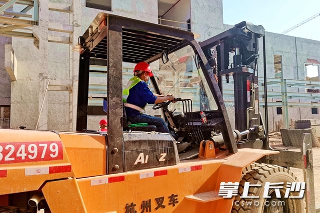 现场，戴着口罩的叉车司机，正在施工中。