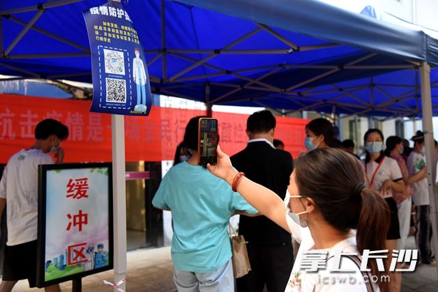 在和润园社区，居民扫健康码后，排队准备进行核酸检测。