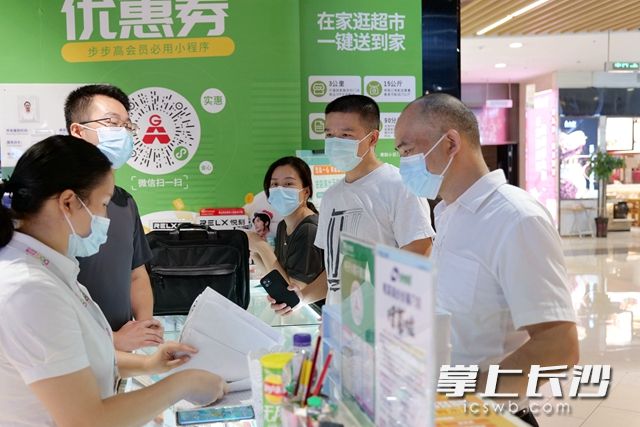 检查组对梅溪湖步步高超市进货台账进行查阅。