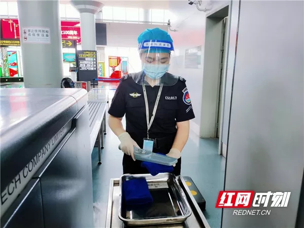 长沙机场安全检查站人身检查岗位员工在旅客过检后为手持金属探测器消毒。