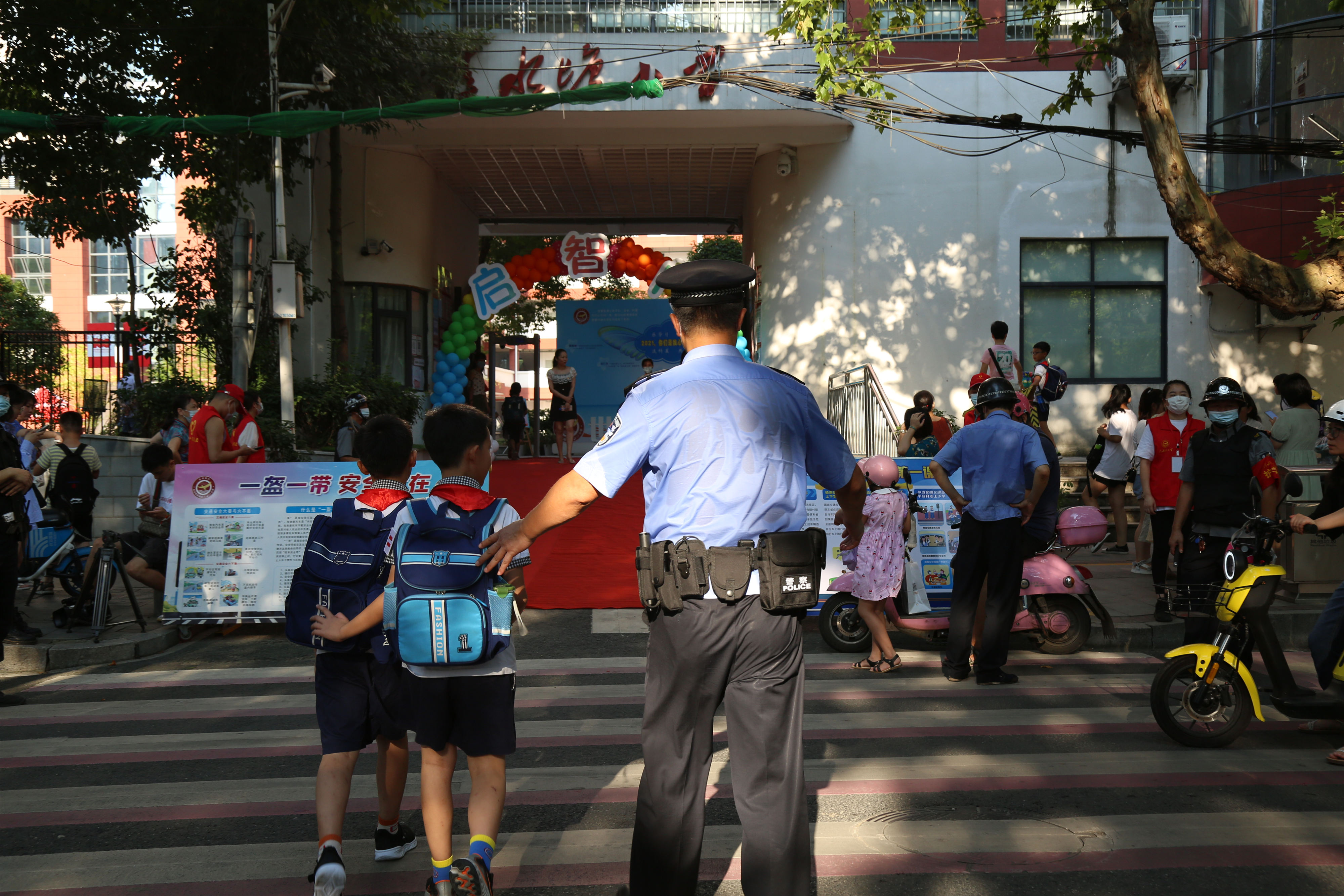在学校门口，长沙公安民警正在维护秩序，守护学生安全过马路。 长沙晚报通讯员 胡喆 供图