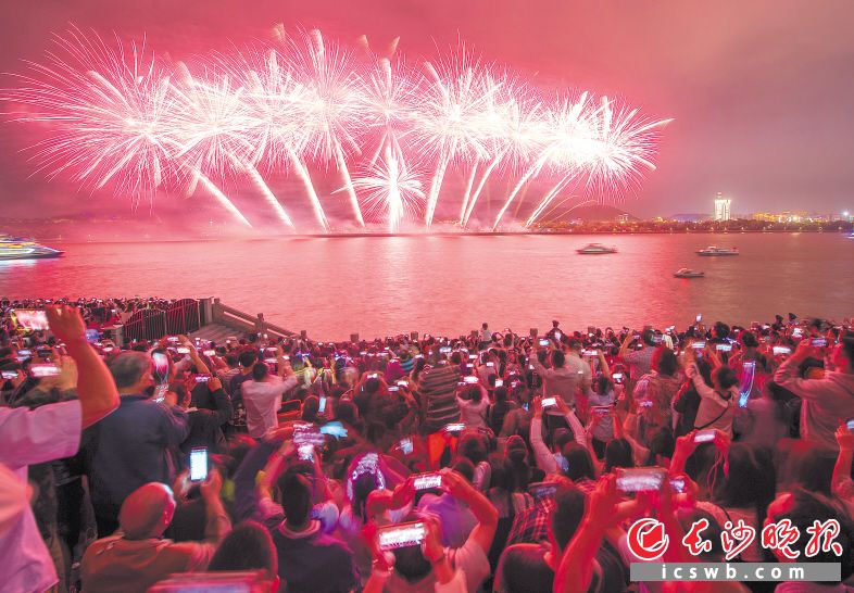 市民们在湘江东岸一起观赏橘子洲烟花秀。