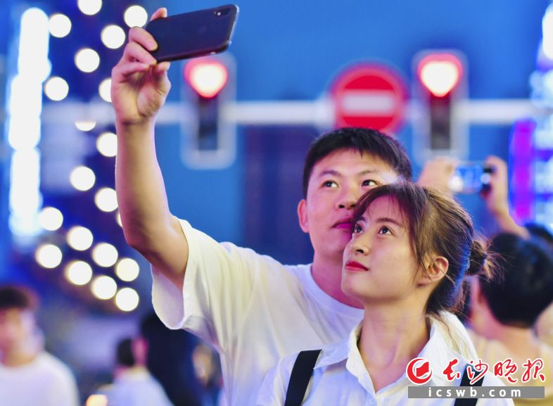 爱心红绿灯、粉红斑马线……这是一对情侣在爱心红绿灯前自拍打卡。
