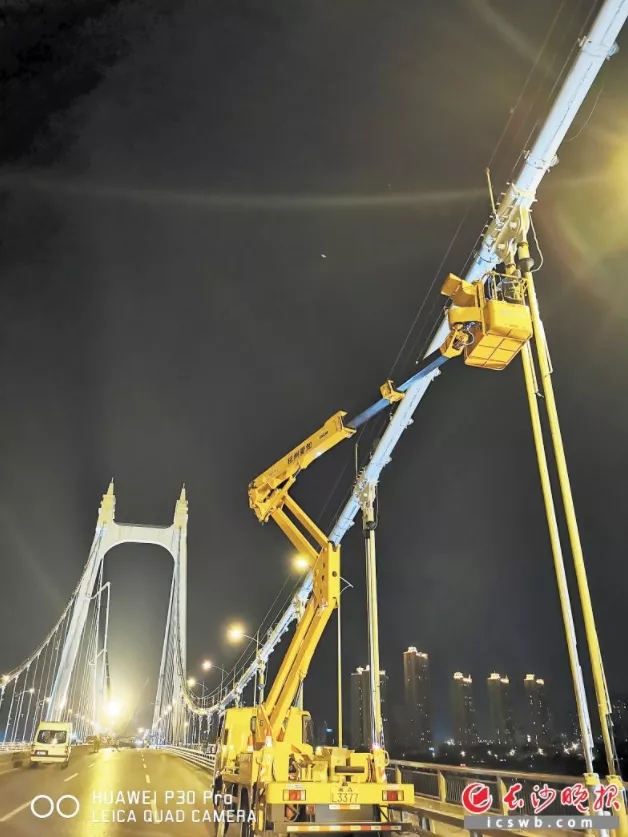 ▲在三汊矶大桥悬索上安装传感器。长沙晚报通讯员梁彪供图