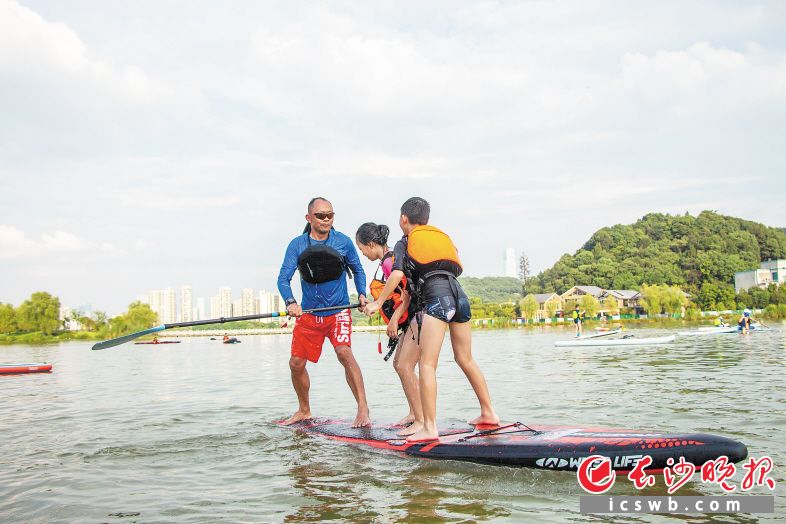 在月湖公园，桨板教练在和学生互动。　受访者夏江南 摄