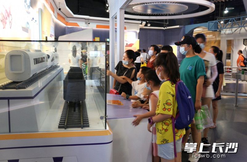 在湖南省科技馆轨道展厅，学生探秘列车车厢的连接。