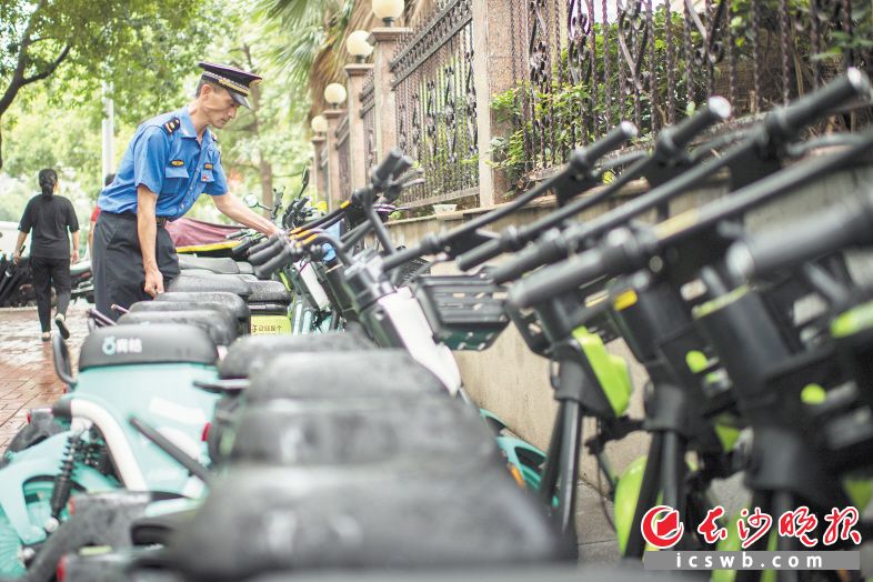 共享单车（电动车）管理是一道新的城市管理课题，长沙城管与交通、公安交警迅速开展联合行动，规范管理。黄启晴 摄