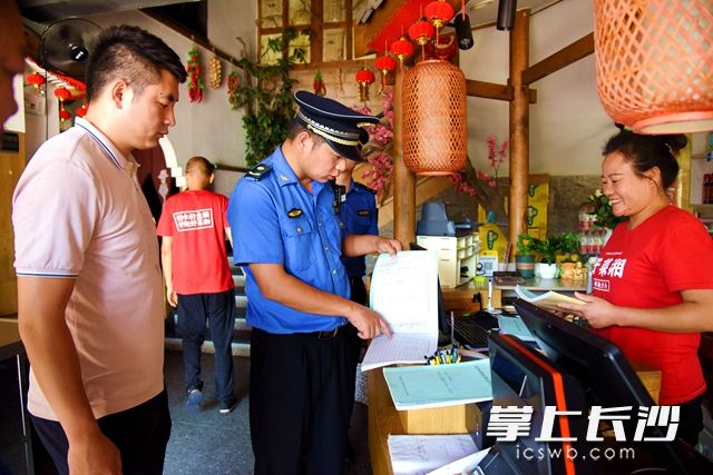 高新区城管执法大队执法人员及社区工作人员到餐饮门店检查油烟净化器定期清洗台账等。