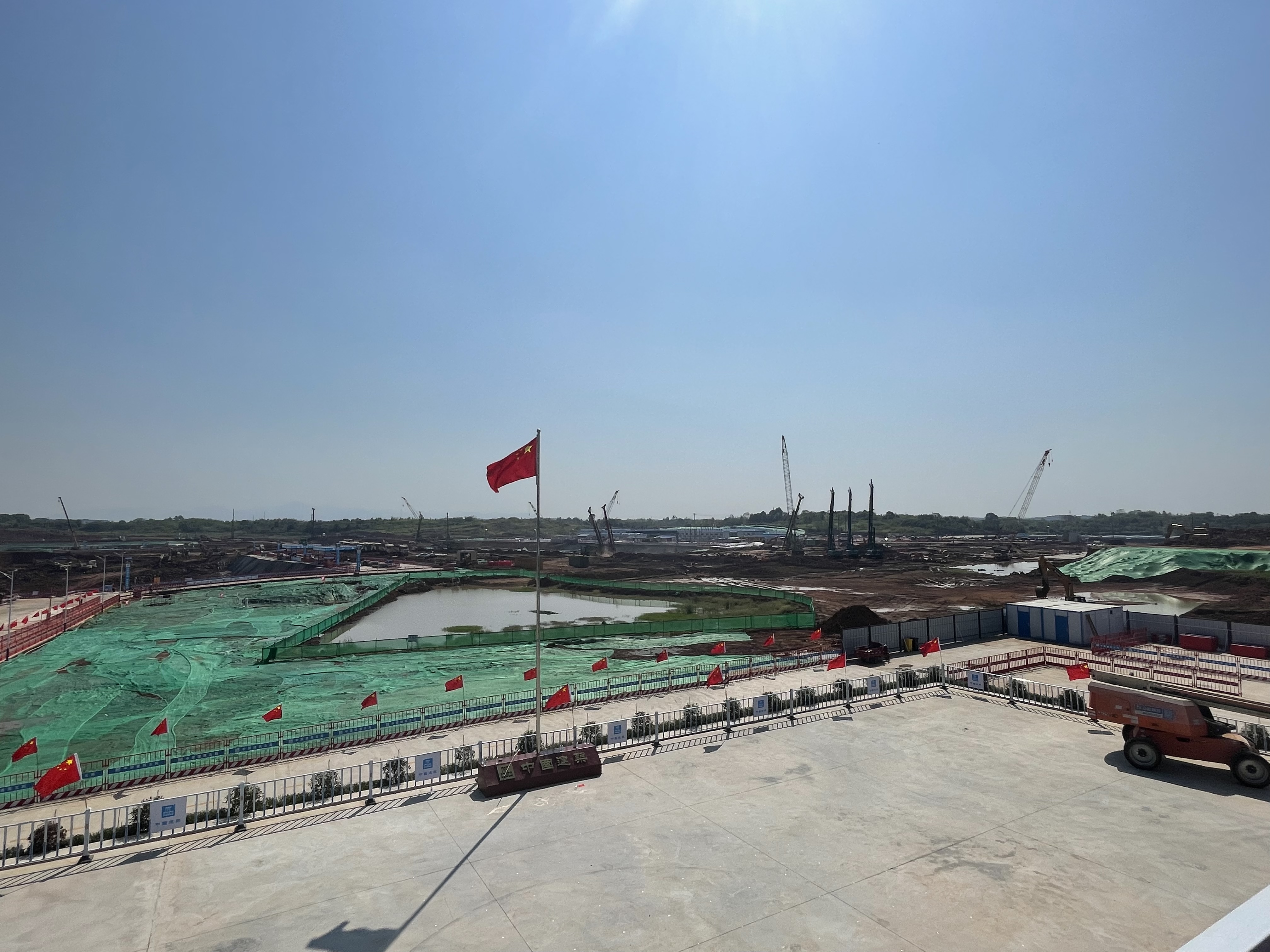 一面鲜艳的五星红旗高高飘扬在项目工地现场，国庆长假期间，项目千名建设者坚守现场施工。