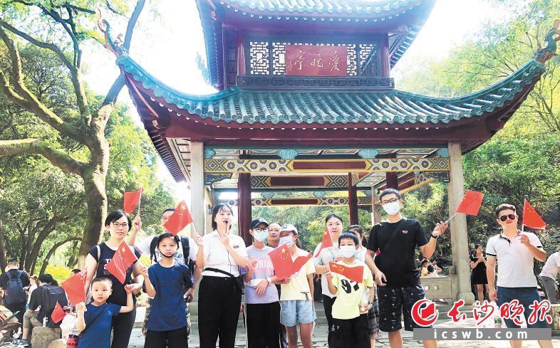 在修缮一新的爱晚亭前，景区讲解员在国庆假期为游客提供全天候免费红色讲解。周宁 供图