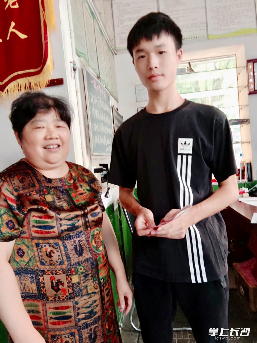 高分考取哈工大深圳校区的周麒来找章姨补“兑奖”。受访者供图