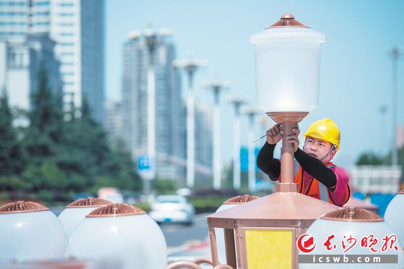 今年以来，长沙城管部门强力实施“百日奋战 扮靓星城”市容环境整治。图为今年6月，工作人员在岳麓大道更换新式路灯。 　　长沙晚报全媒体记者 黄启晴 摄