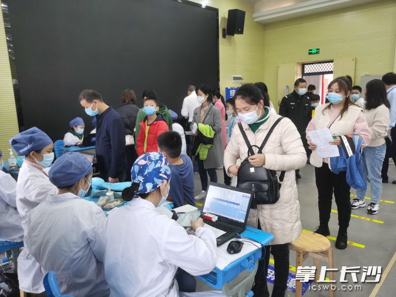 在接种区，学生家长依次登记孩子相关信息。