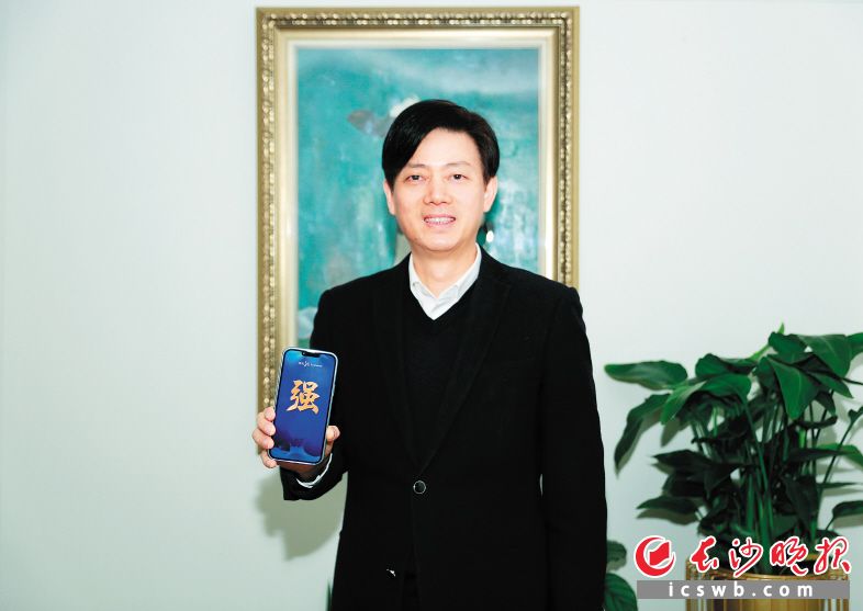 澳优董事长颜卫彬展示他推荐的“强”字。　　长沙晚报通讯员 罗胜新 摄