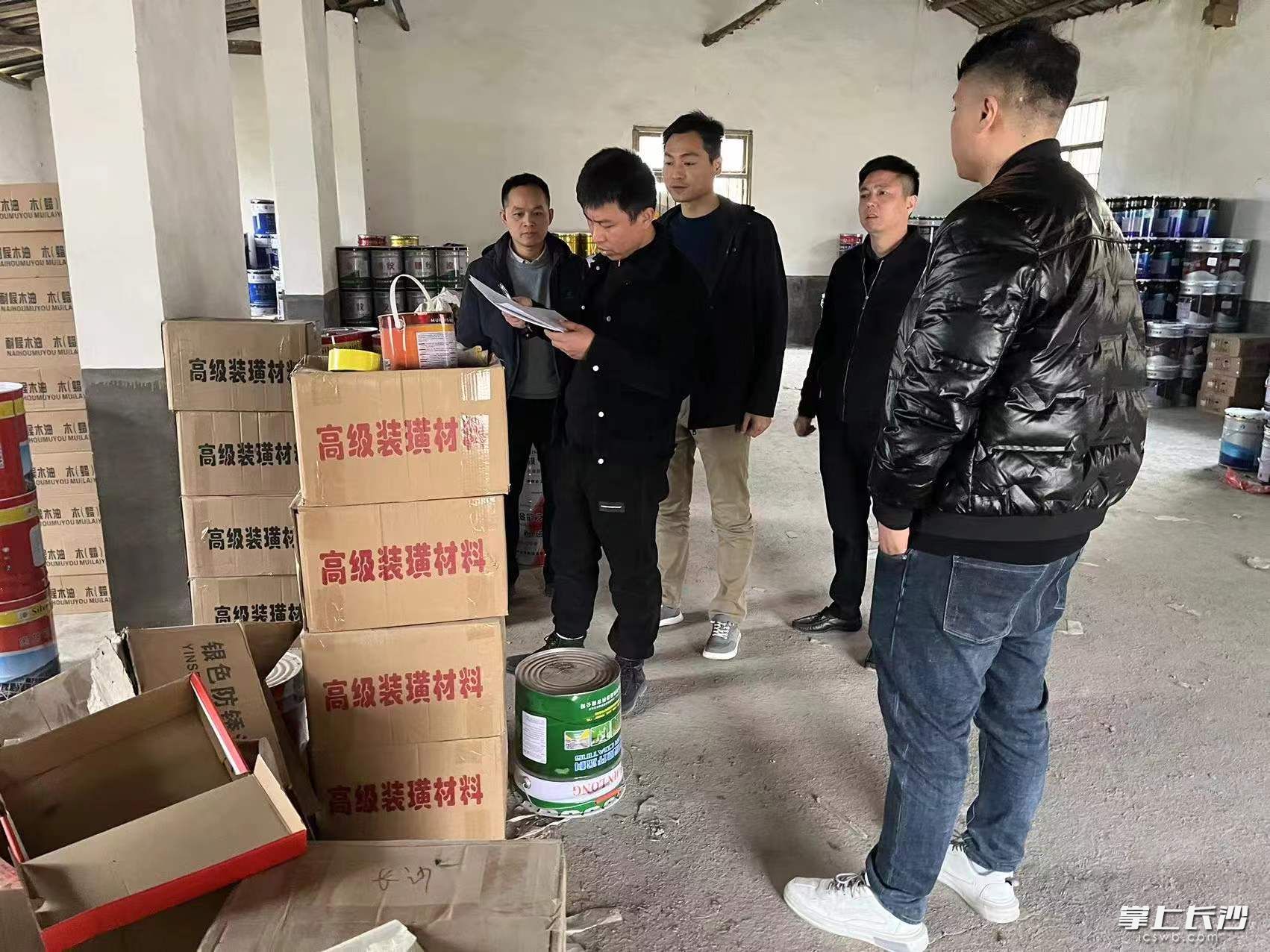 执法人员对仓库内危化品进行现场检查