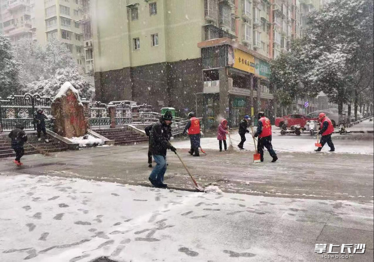 12月26日，社区志愿者在小区门口铲雪。
