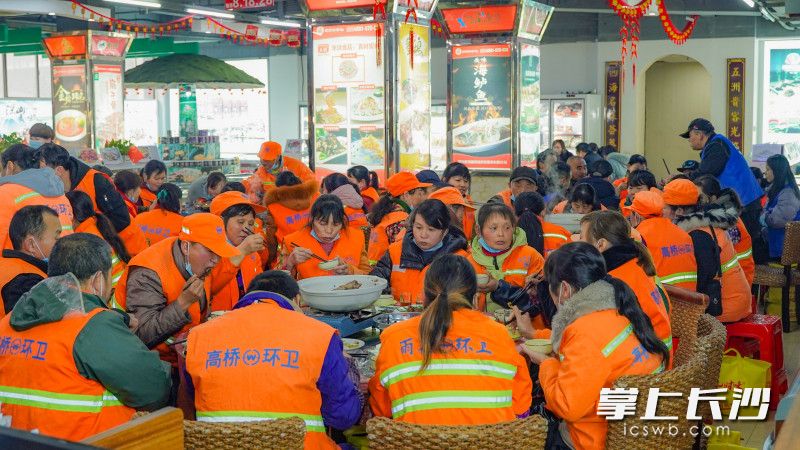 张尚友邀请高桥环卫工人来到他的店铺吃免费的团圆饭，这一善举已经持续了13年。均为长沙晚报全媒体记者 刘晓敏 摄