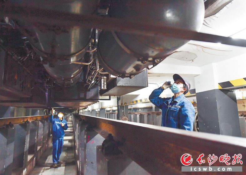 刘婉怡（右）和同事夏勇强在检修车辆，日常检修一辆列车需要2人一组，检修时间约45分钟。
