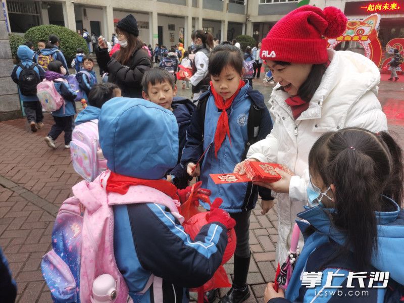 清水塘第三小学党支部书记蒋蔚东在给孩子们派发开学“红包”。