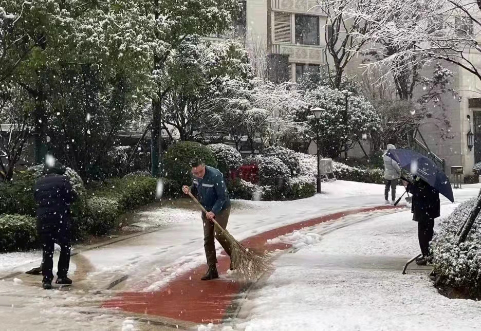 物业人员正在小区扫雪。