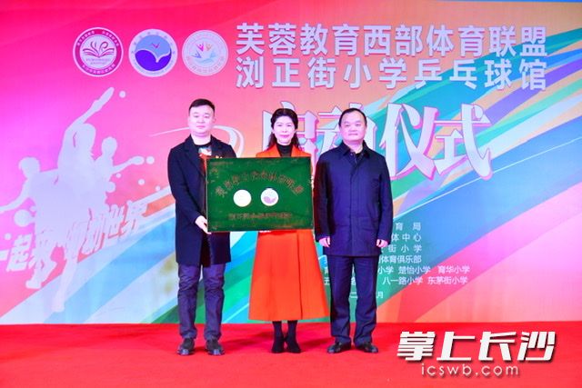 芙蓉区教育局党委书记、局长曾志伟（右一）为西部体育联盟浏正街小学乒乓球馆授牌。