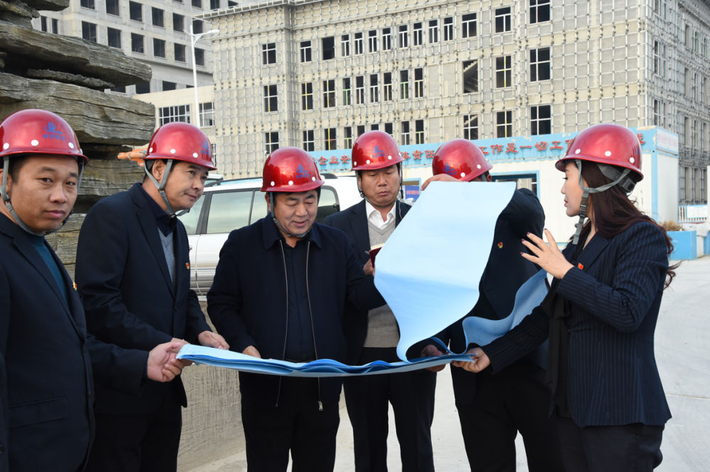 这是王俊祥（左三）在赤峰市中医蒙医医院项目查看图纸。（受访者供图）