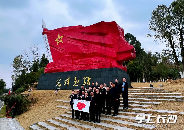 来自秋收红土地上的乡镇干部，签约前在文家市秋收广场硕大的红旗雕像前合影。均为长沙晚报全媒体记者 颜开云 摄