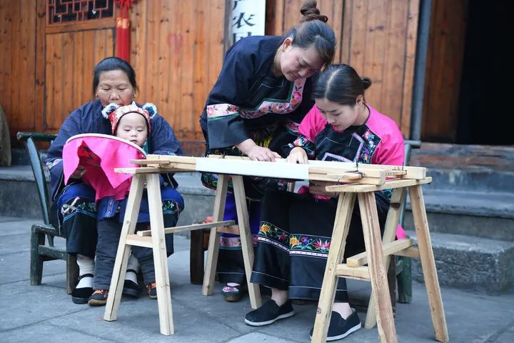 返乡大学生施林娇(右一)在湖南湘西十八洞村学习苗绣(2020年4月25日摄) 薛宇舸摄 / 本刊